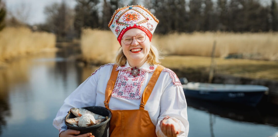 Visit Saaremaa - Naine naeratamas, kala ämber käes - meeleolufoto